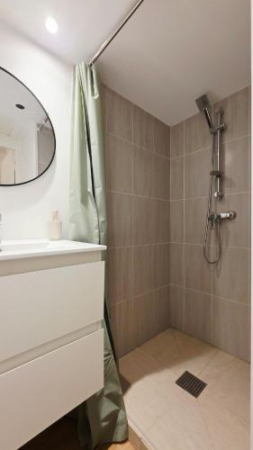 a bathroom with a shower and a sink and a mirror at La Pause - Centre-ville in Bourbourg