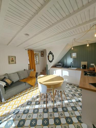Una cocina y una sala de estar con una mesa. en Écolieu La Bernarde - Gîte Graphique, en Dompnac