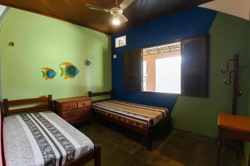 two beds in a room with green and blue walls at Solar do Sal in Salinópolis