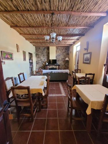 een eetkamer met tafels en stoelen en een open haard bij Ñawpa Wasi in Humahuaca