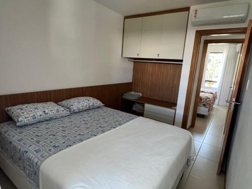 a bedroom with a bed and a cabinet and a window at Bioflora 69 Itacimirim in Camacari