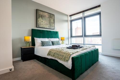 1 dormitorio con 1 cama verde grande y ventanas en Leeds City Views - Riverside Living - Sleeps 8 - Balcony, en Central Station