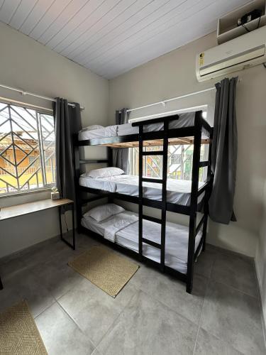 twee stapelbedden in een kamer met een raam bij Zig Zag Hostel in Itacaré