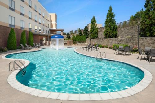 a swimming pool with a fountain in a courtyard at Fairfield Inn & Suites by Marriott Pigeon Forge in Pigeon Forge