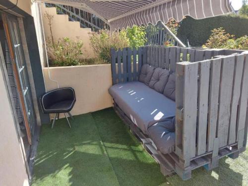 a dog bed in a fence with a chair at Magnifique Studios proche de Paris dans le Yvelines in Ecquevilly