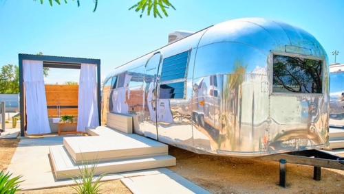 a silver bus parked in front of a building at Acres Landing in Desert Hot Springs