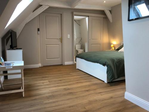 サントメールにあるMaison L'Esperance chic et calmeのベッドと机とテレビのある寝室