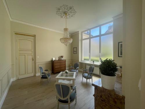 サントメールにあるMaison L'Esperance chic et calmeのリビングルーム(椅子、テーブル付)、窓が備わります。