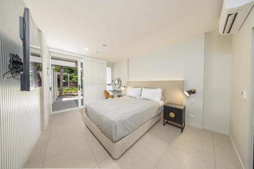 una camera da letto bianca con un letto e una finestra di Picnic Bay Hotel a Picnic Bay