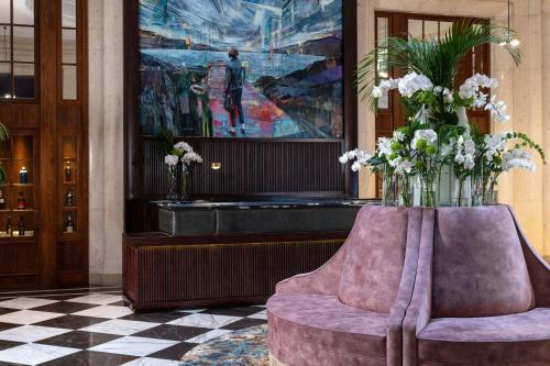 a lobby with two chairs and a vase of flowers at The Edinburgh Grand, a Luxury Collection Hotel, Edinburgh in Edinburgh