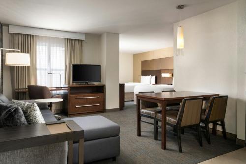 a hotel room with a living and dining room at Residence Inn by Marriott Springfield Chicopee in Chicopee