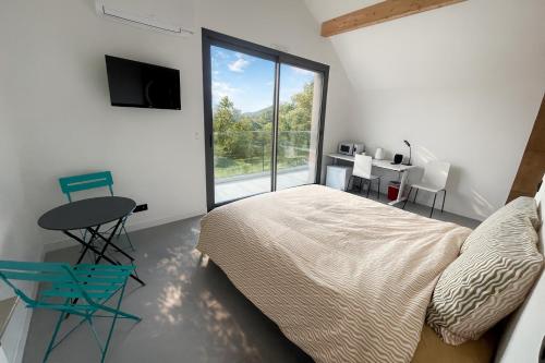 Un dormitorio con una cama y una mesa y una ventana. en Incroyable vue, en Bouliac