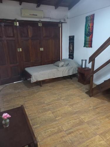 una habitación con una cama en la esquina de una habitación en Romu, en Villa Gesell