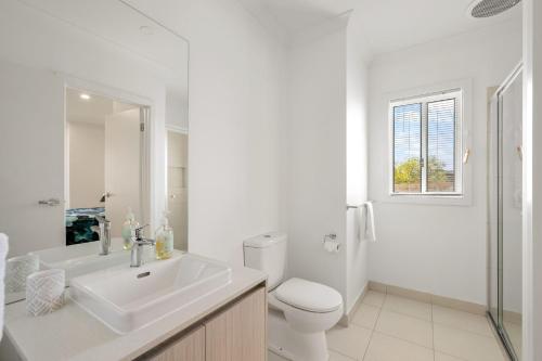 サンレモにあるBay Skies Retreatの洗面台とトイレを備えた白いバスルーム