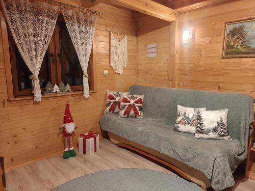 un soggiorno con un divano grigio con regali di Natale di Nowoczesny Domek Góralski a Kielce