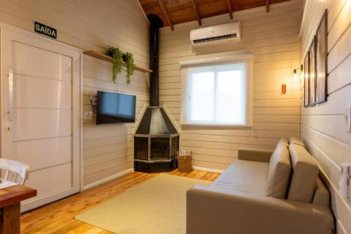 a living room with a couch and a television at Condado de Urubici - Cabana in Urubici