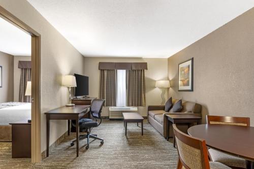 a hotel room with a bed and a living room at Best Western Plus Pembina Inn & Suites in Winnipeg