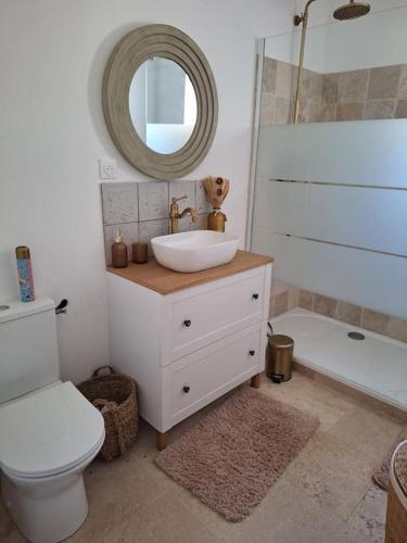 a bathroom with a sink and a toilet and a mirror at Maison type T3 à Ventabren in Ventabren