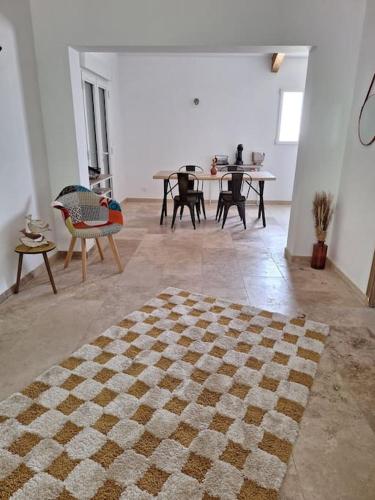 a living room with a checkered rug on the floor at Maison type T3 à Ventabren in Ventabren