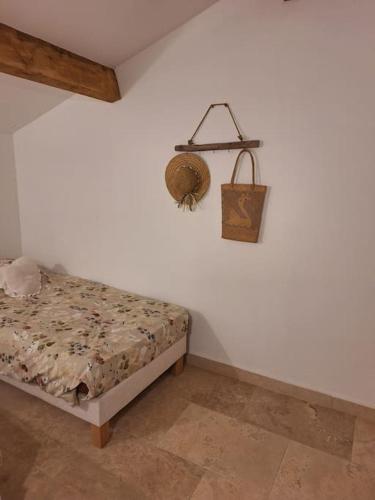 Dormitorio con cama y cesta en la pared en Maison type T3 à Ventabren, en Ventabren