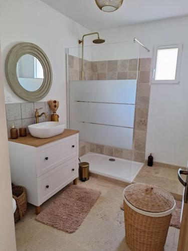 Un baño con lavabo y ducha con espejo. en Maison type T3 à Ventabren, en Ventabren