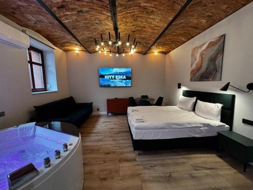 a room with a bed and a bath tub at Rybaki Sauna & Jacuzzi Apartment in Poznań