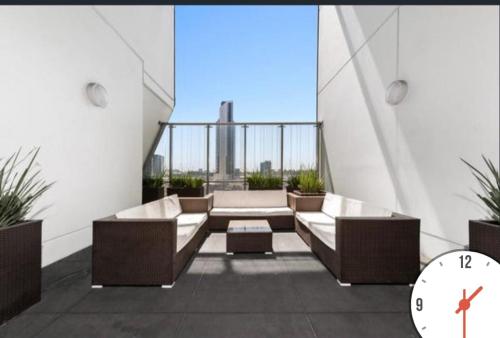 Seffadom apartments Melbourne cbd في ملبورن: غرفة بها أريكتان وساعة في مبنى
