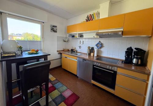 a small kitchen with yellow cabinets and a counter top at Ferienwohnung-Maren in Marienleuchte