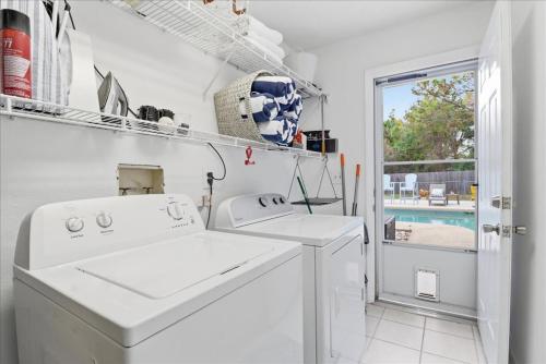 a white laundry room with two washing machines and a window at Crystal Blue Haven in Crystal River