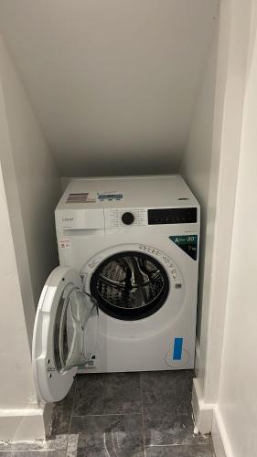 a washer and dryer in a corner of a room at La Rose Serenity Residence Elegant Rooms in London
