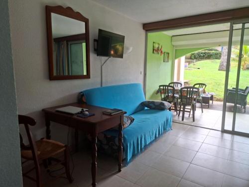 un salon avec un canapé bleu et une table dans l'établissement Ty Alice, à Sainte-Anne