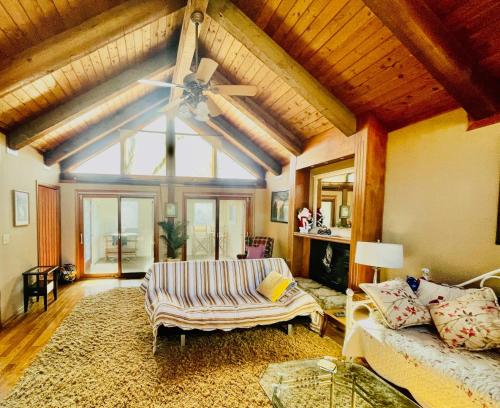 een woonkamer met een plafondventilator en een bank bij Longview Lake Getaway 4-Bedroom house in Lees Summit