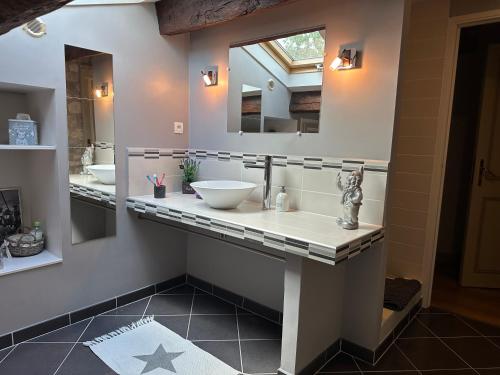 a bathroom with a sink and a mirror at Domaine de pierre blanche in Pern
