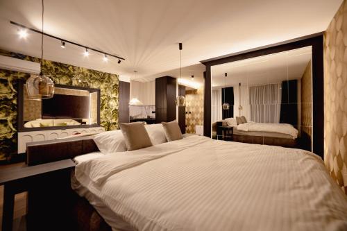 ノヴィサドにあるKronの大きな白いベッドと鏡のある寝室