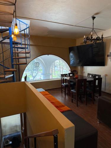 a living room with a table and a large window at La terraza del Portal in Arequipa