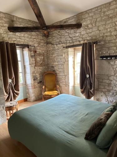 a bedroom with a large bed and a chair at Domaine de pierre blanche in Pern