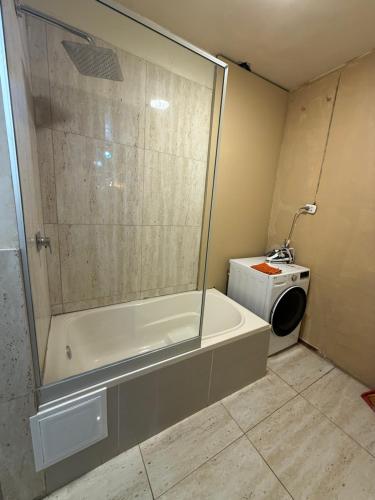 a bathroom with a tub and a washing machine at La terraza del Portal in Arequipa