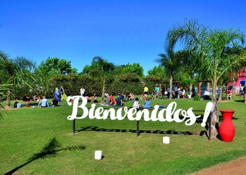 uma placa em um parque com pessoas sentadas na grama em Cabañas La Soñada em Chajarí
