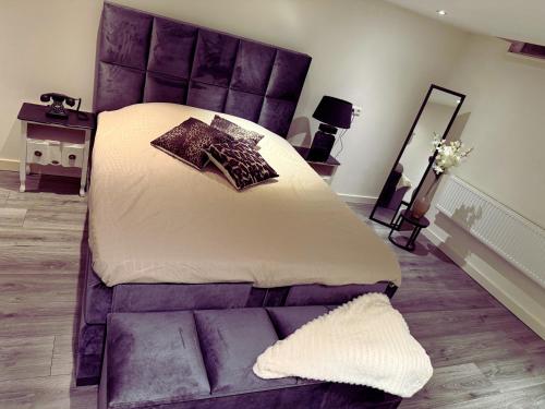 Un dormitorio con una cama grande con cabecero morado. en Woonhuis 170m2 Rotterdam Centrum, en Róterdam