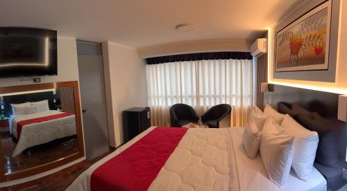 een hotelkamer met een bed en twee stoelen bij City Tower Hotel in Lima