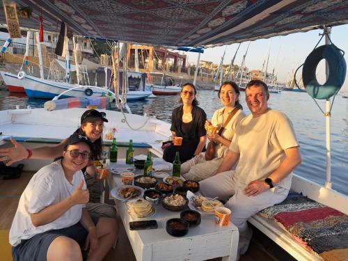 a group of people sitting around a table on a boat at Leyla Eco Resort Queen Suites in Luxor