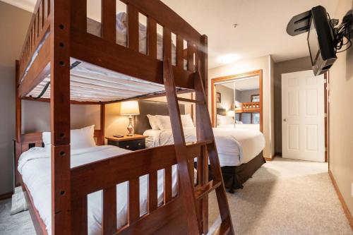 a bedroom with two bunk beds and a mirror at Aspens Lodge 220 by Outpost Whistler in Whistler