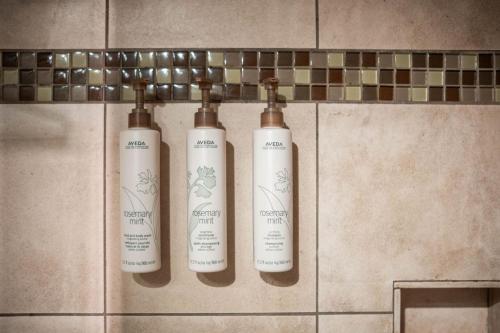 three shampoo bottles on a wall in a bathroom at Aspens Lodge 220 by Outpost Whistler in Whistler
