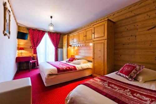 シャテルにあるHôtel Le Tremplinの木製の壁のベッドルーム1室(ベッド2台付)