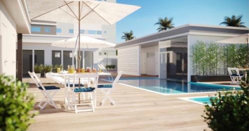 Una villa con piscina, mesa y sillas. en Cond Millenium residênce, en Juiz de Fora