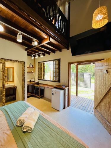 a bedroom with a large bed with towels on it at Cabana na Natureza Com Hidro - Baoba Suites in Bombinhas