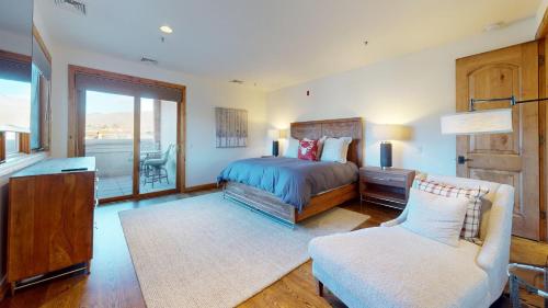 een slaapkamer met een bed, een stoel en een raam bij Leadville Condo 320 in Ketchum