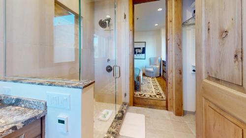 een badkamer met douche en glazen deur bij Leadville Condo 320 in Ketchum