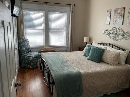 a bedroom with a bed and a chair and a window at The Farmhouse at Wolfehaven in Asheville
