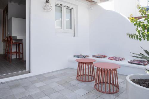 Un patio con dos taburetes y una mesa. en Casa Poco, 150 meters from Ornos Beach, en Ornos